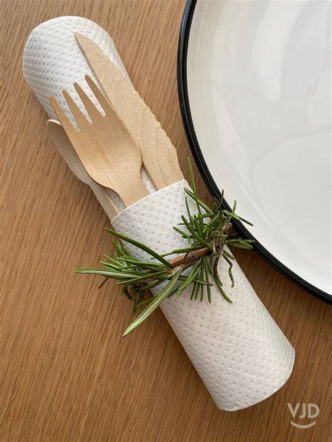 Serviette roulée nœud romarin table