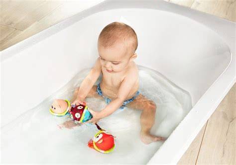 bébé jouant avec balles de bain colorées