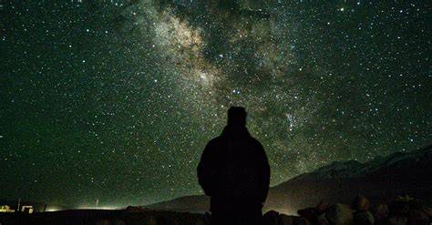 Observateur allongé sous ciel étoilé