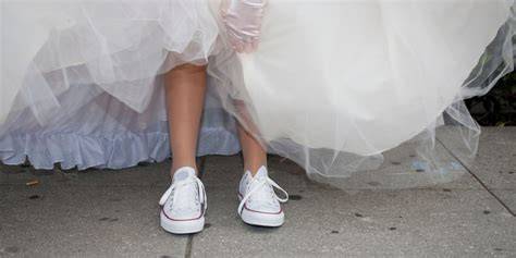 Baskets blanches sous robe de mariée