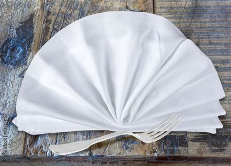 Serviette pliée en rosette sur assiette